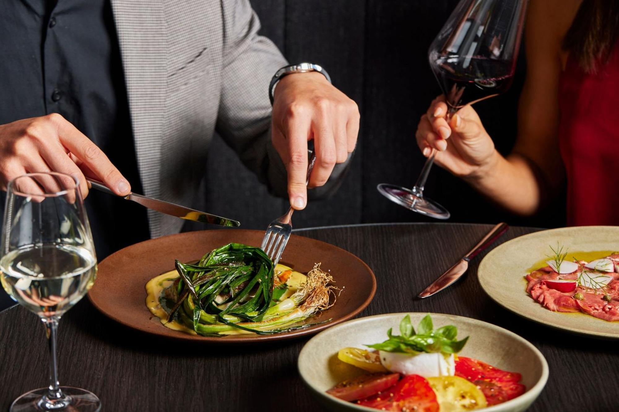 墨尔本港区万豪酒店 外观 照片 A man using a knife and fork to cut into a meal
